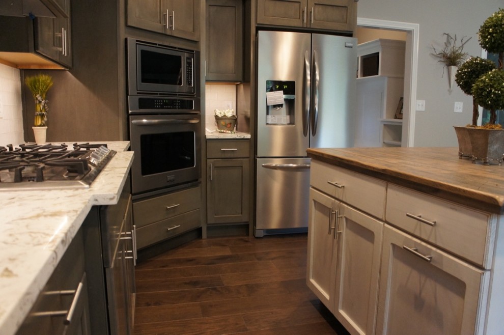 Eat-in kitchen - transitional u-shaped eat-in kitchen idea with flat-panel cabinets, white backsplash, stainless steel appliances and an island