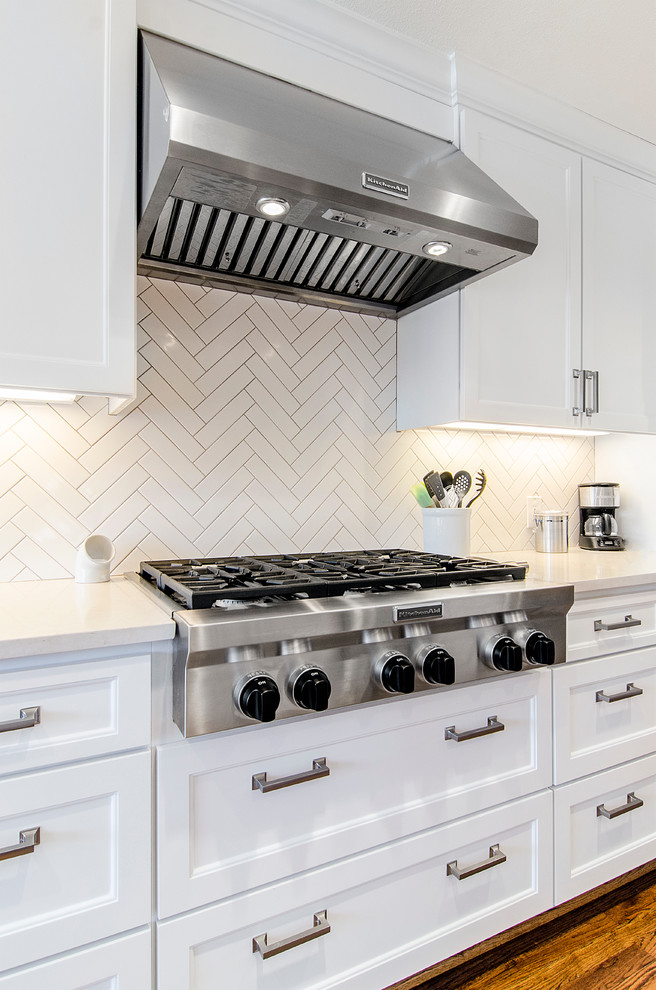 Eat-in kitchen - transitional u-shaped eat-in kitchen idea in Dallas with an undermount sink, flat-panel cabinets, white cabinets, granite countertops, porcelain backsplash, stainless steel appliances and white backsplash