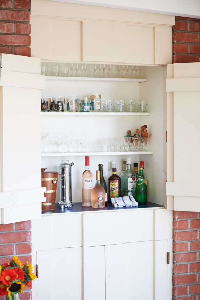 This is an example of a small midcentury single-wall wet bar in Santa Barbara with no sink, white cabinets, wood benchtops, white splashback, timber splashback and black benchtop.