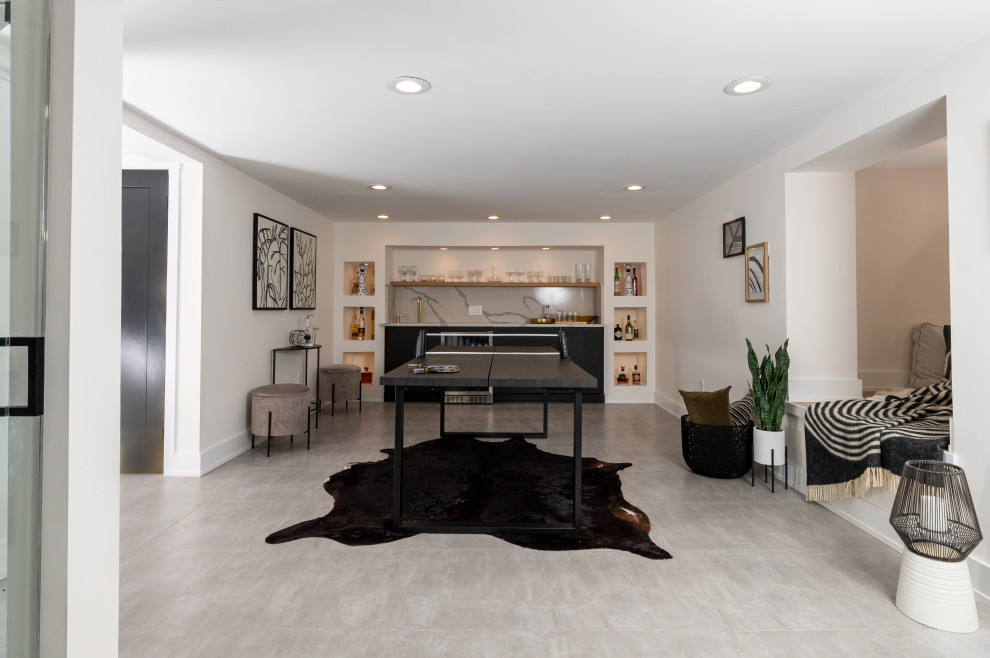Photo of a large modern walk-out basement in Philadelphia with a home bar, white walls, a ribbon fireplace, a metal fireplace surround and grey floors.