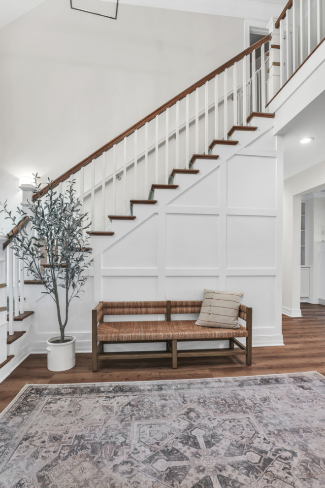 Design ideas for a large classic foyer in Jacksonville with white walls, vinyl flooring, a single front door, brown floors and wainscoting.