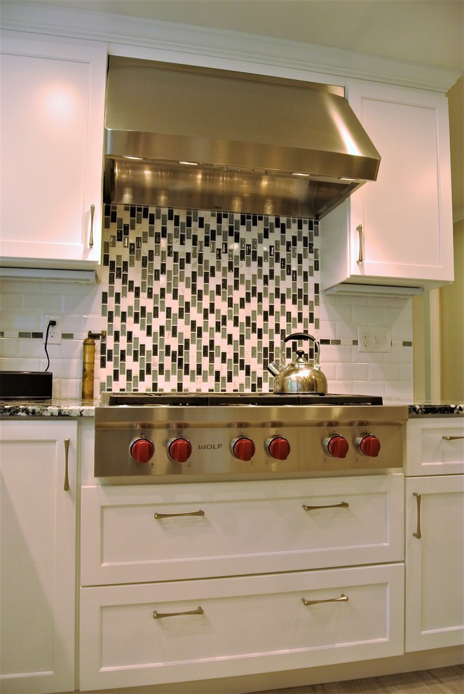 Example of a transitional kitchen design in Boston with an undermount sink, shaker cabinets, granite countertops, subway tile backsplash, stainless steel appliances and an island