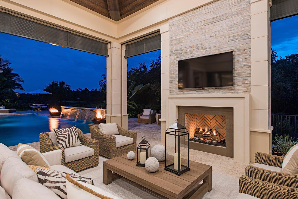 Expansive transitional backyard patio in Miami with a fire feature and a roof extension.