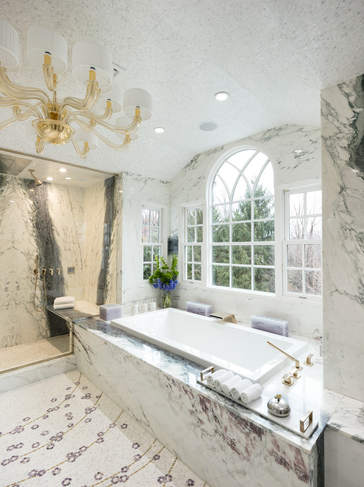 This is an example of an expansive modern master bathroom in New York with furniture-like cabinets, white cabinets, an undermount tub, an alcove shower, a one-piece toilet, white tile, marble, white walls, marble floors, an undermount sink, quartzite benchtops, white floor, a hinged shower door and purple benchtops.