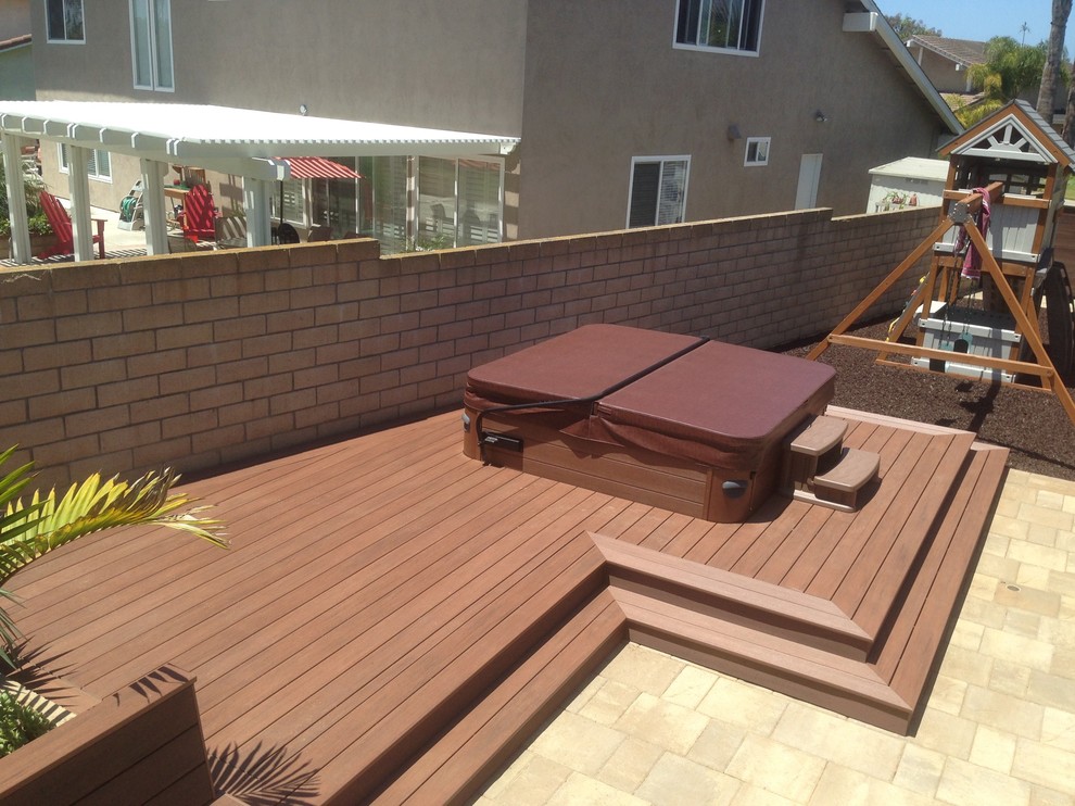 This is an example of a mid-sized modern backyard deck in Orange County with a water feature.