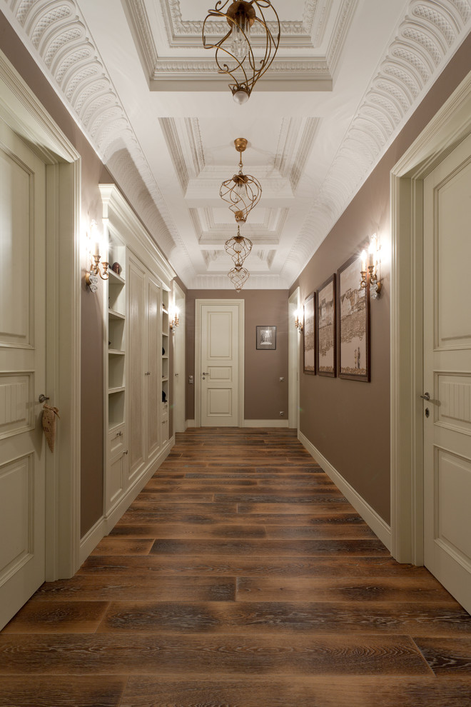 This is an example of a mid-sized traditional hallway in Moscow with brown walls and dark hardwood floors.
