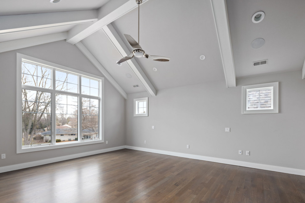 Idées déco pour une chambre craftsman avec un mur gris, un sol en bois brun et un plafond voûté.