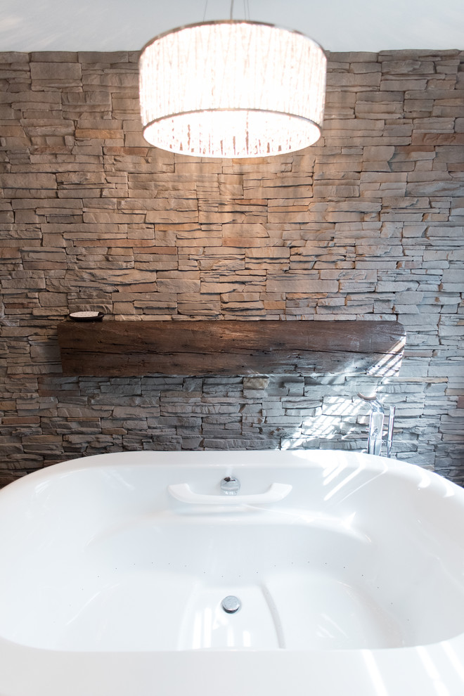 Inspiration for a mid-sized country master bathroom in Toronto with shaker cabinets, dark wood cabinets, a freestanding tub, gray tile, beige walls, porcelain floors, a vessel sink and granite benchtops.