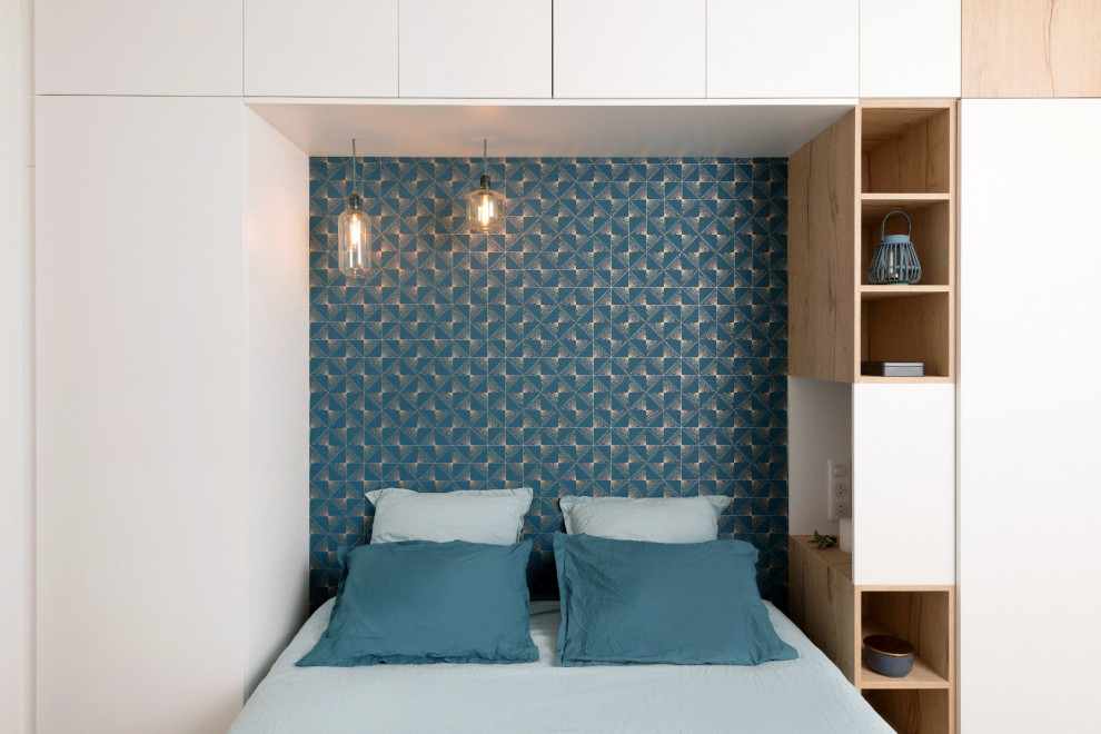 Exemple d'une chambre parentale blanche et bois tendance en bois de taille moyenne avec un mur bleu, parquet clair et dressing.