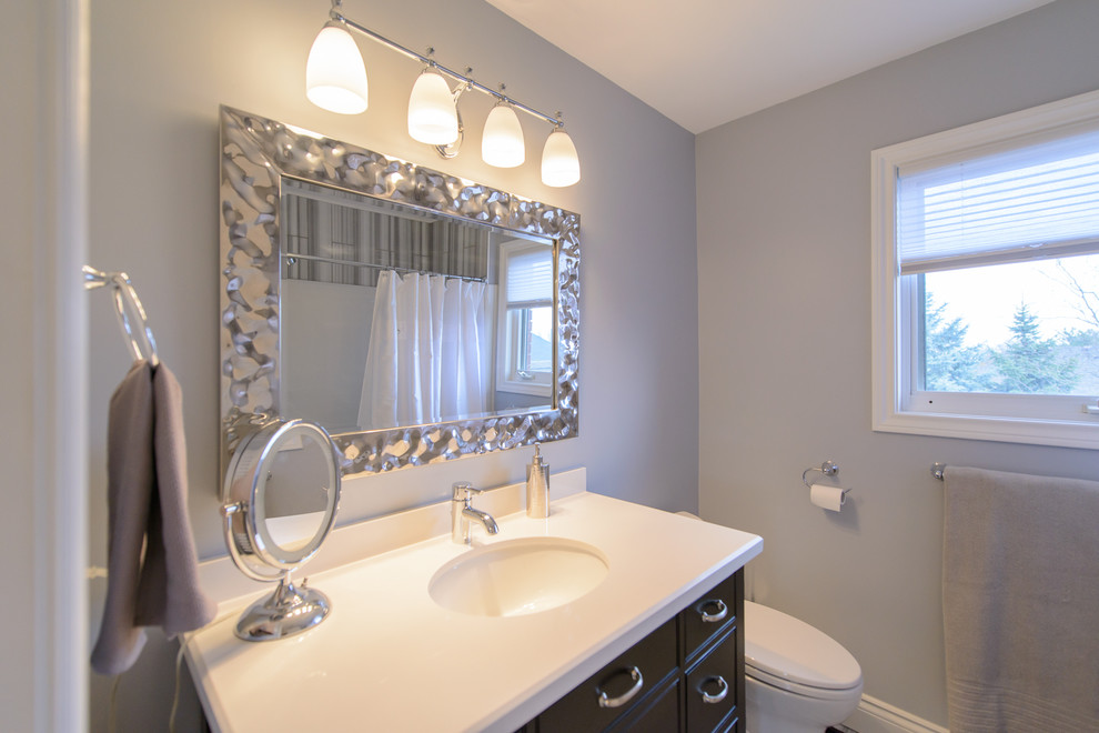 Mid-sized traditional 3/4 bathroom in Toronto with recessed-panel cabinets, dark wood cabinets, an alcove tub, an alcove shower, a one-piece toilet, a drop-in sink, dark hardwood floors and grey walls.
