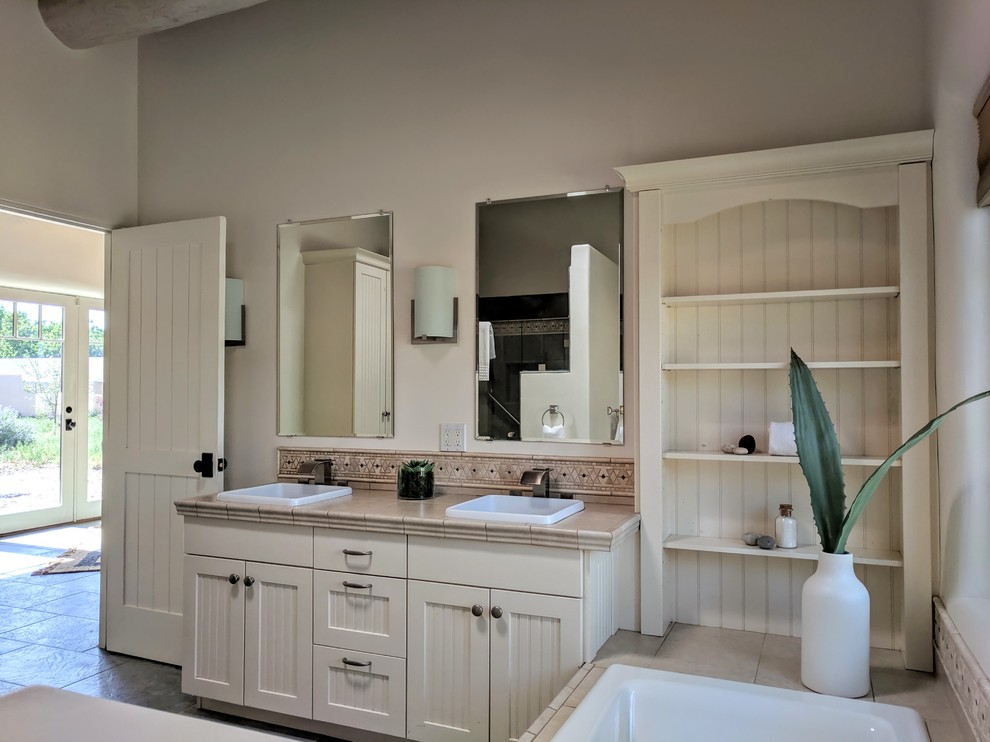 Design ideas for a mid-sized master bathroom in Other with beige cabinets, a drop-in tub, white walls, slate floors, tile benchtops, grey floor, a hinged shower door and beige benchtops.