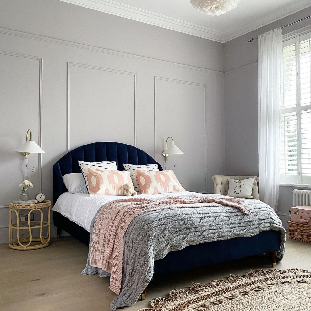 Country Schlafzimmer mit blauer Wandfarbe, hellem Holzboden und braunem Boden in Surrey