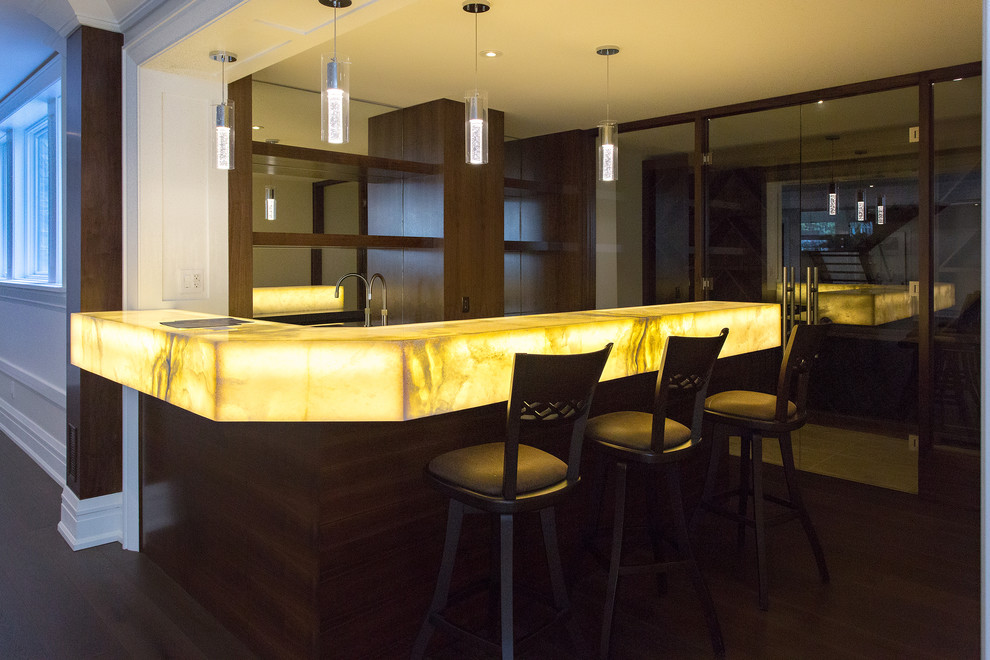 Inspiration for a large contemporary l-shaped seated home bar in Toronto with dark hardwood floors, brown floor, an undermount sink, open cabinets, brown cabinets, onyx benchtops, mirror splashback and yellow benchtop.