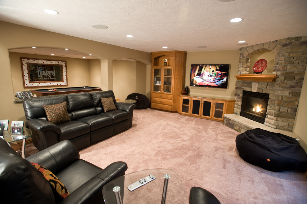 This is an example of a traditional basement in Omaha with a corner fireplace.