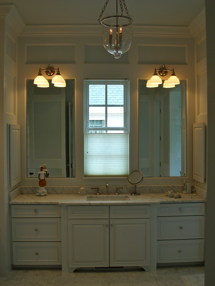Traditional bathroom in Raleigh with an undermount sink, furniture-like cabinets, white cabinets, marble benchtops and marble floors.