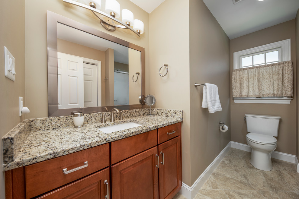 Example of a transitional bathroom design with raised-panel cabinets and an undermount sink