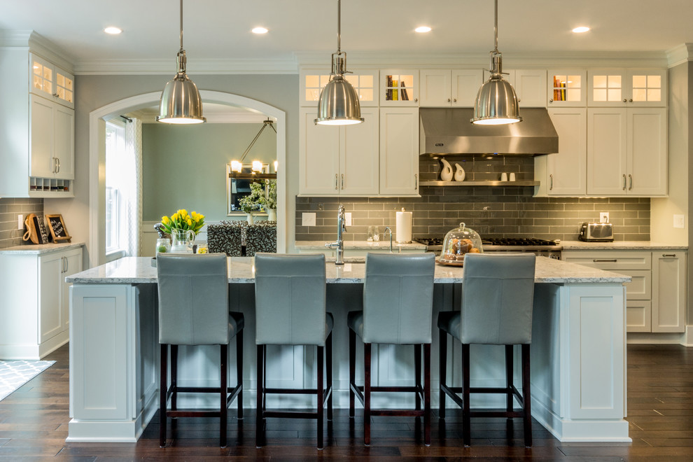 This is an example of a large transitional u-shaped eat-in kitchen in Detroit with an undermount sink, shaker cabinets, white cabinets, quartz benchtops, blue splashback, glass tile splashback, stainless steel appliances, dark hardwood floors and with island.