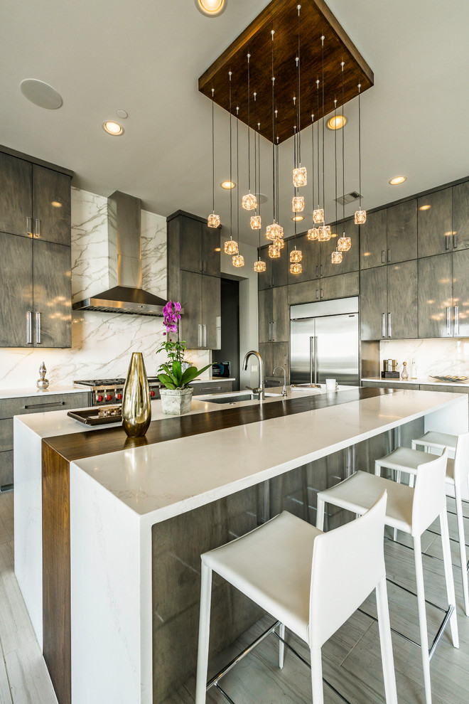 Photo of a large contemporary kitchen in Austin with flat-panel cabinets, quartzite benchtops, white splashback, marble splashback, stainless steel appliances, ceramic floors, with island, an undermount sink, brown cabinets, grey floor and multi-coloured benchtop.