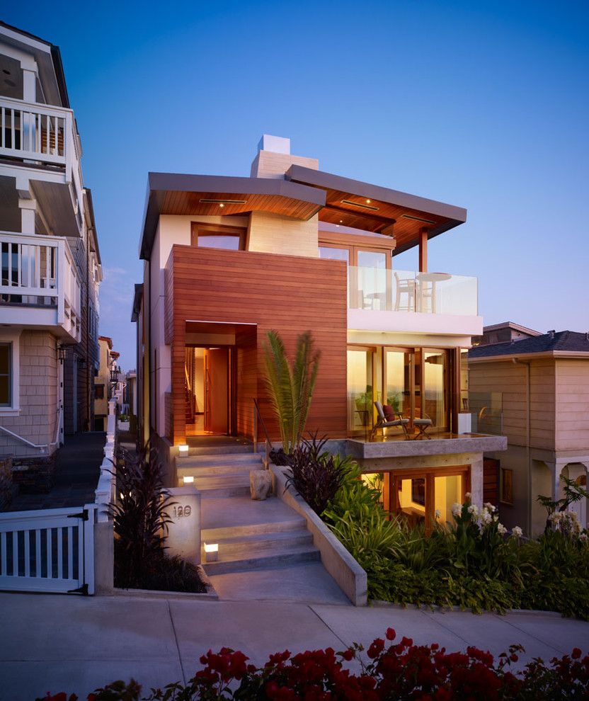 Inspiration for a mid-sized contemporary three-storey house exterior in Los Angeles with wood siding and a metal roof.