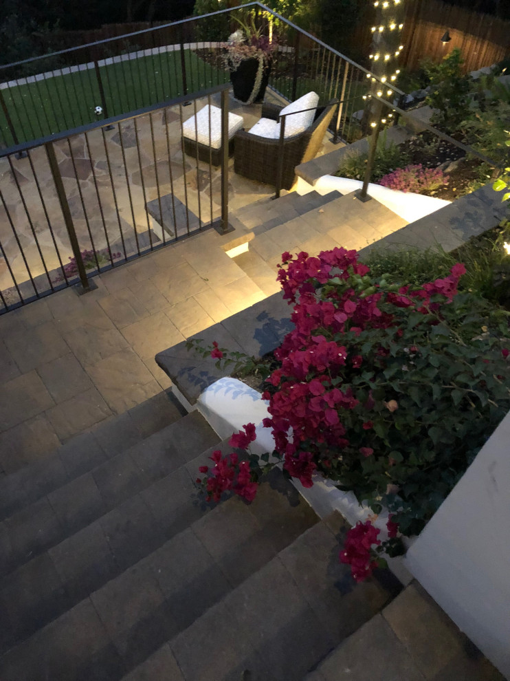 This is an example of a large modern courtyard patio in San Francisco with a water feature and natural stone pavers.