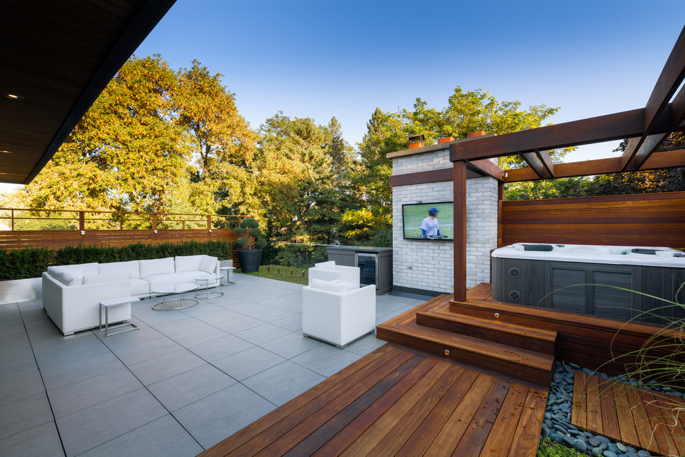 Inspiration for a mid-sized modern backyard patio in Toronto with an outdoor shower and a pergola.
