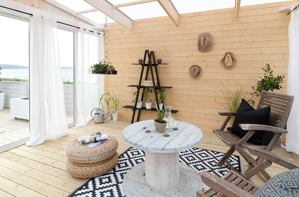 Photo of a mid-sized scandinavian sunroom in Stockholm with light hardwood floors, no fireplace and a glass ceiling.