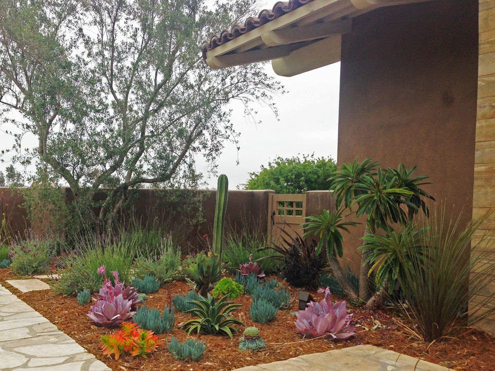 This is an example of a large and desert look side yard full sun xeriscape in San Diego with natural stone pavers.