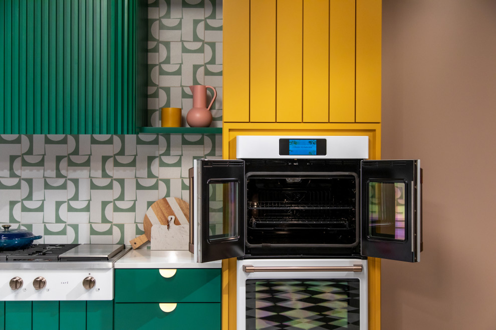 На фото: большая угловая кухня в стиле модернизм с обеденным столом, бирюзовыми фасадами и зеленым фартуком с