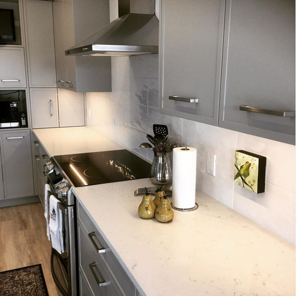 Eat-in kitchen - mid-sized transitional u-shaped light wood floor and beige floor eat-in kitchen idea in Calgary with an undermount sink, recessed-panel cabinets, gray cabinets, quartzite countertops, white backsplash, stainless steel appliances, an island, white countertops and ceramic backsplash