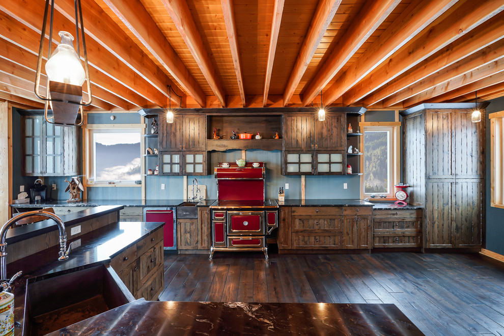 Eat-in kitchen - large rustic galley eat-in kitchen idea with a farmhouse sink, recessed-panel cabinets, brown cabinets, quartzite countertops, colored appliances and an island