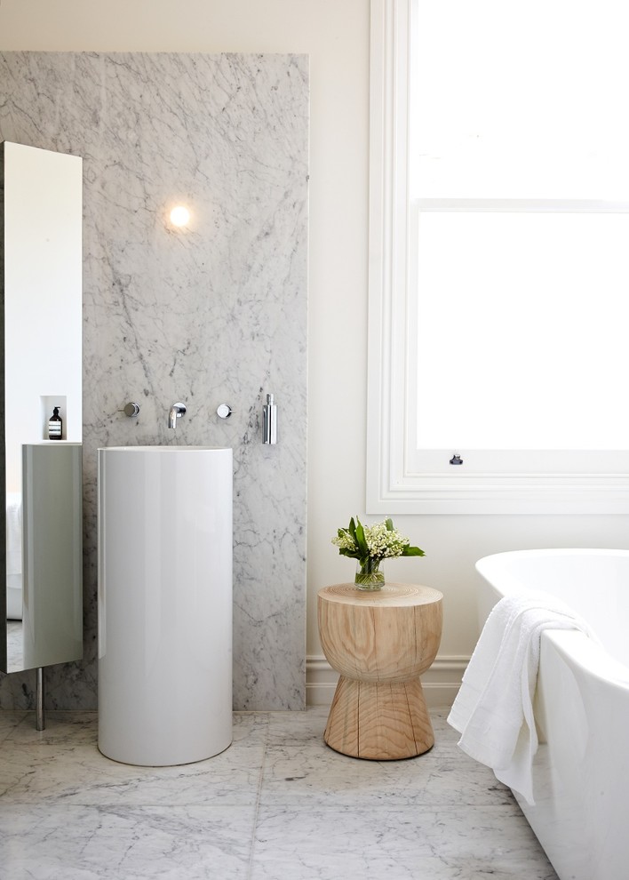 Inspiration for a mid-sized contemporary bathroom in Melbourne with a freestanding tub, white walls, marble floors, marble, gray tile, a console sink and white floor.