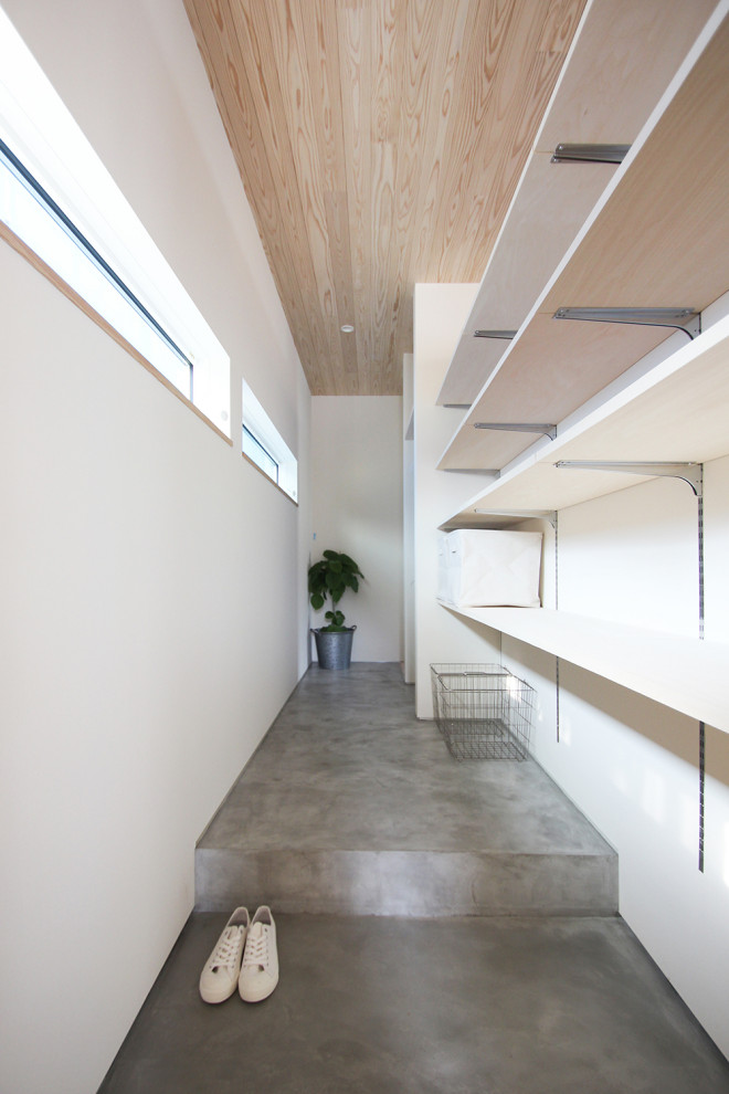 Foto di un corridoio con pareti marroni, una porta singola, una porta in legno scuro, pavimento grigio, soffitto in legno, pareti in perlinato e armadio
