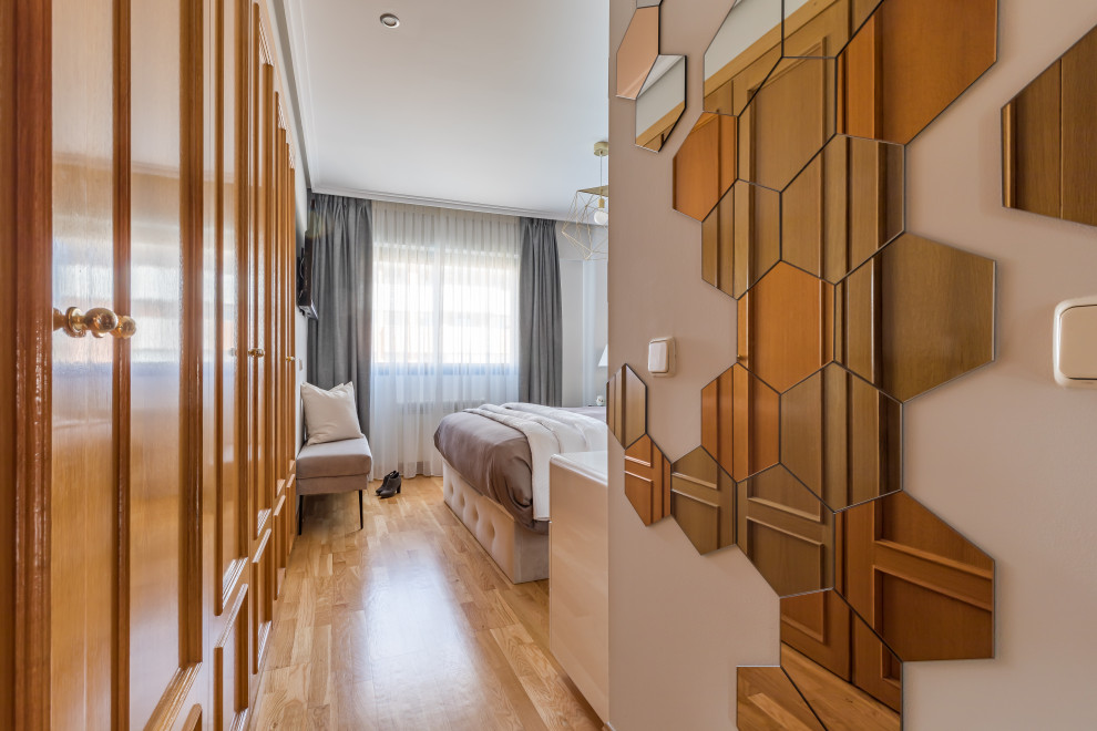 Foto di una camera matrimoniale minimalista di medie dimensioni con pareti grigie, pavimento in legno massello medio e pavimento marrone