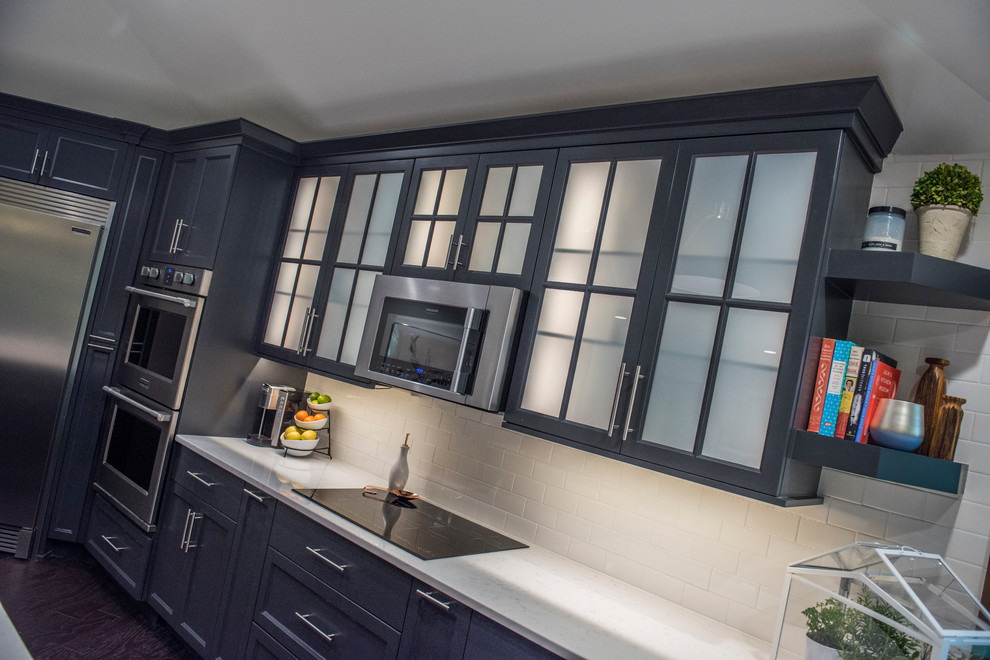 Example of a large transitional u-shaped dark wood floor kitchen design with an undermount sink, beaded inset cabinets, gray cabinets, quartz countertops, white backsplash, subway tile backsplash, stainless steel appliances and an island