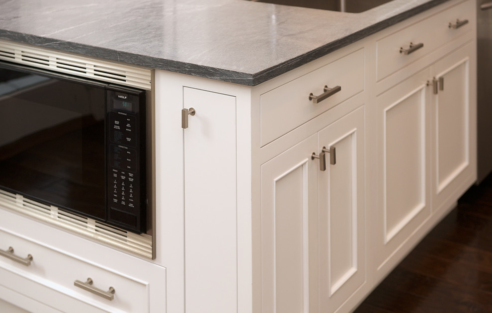 Mid-sized transitional l-shaped dark wood floor and brown floor open concept kitchen photo in San Francisco with an undermount sink, recessed-panel cabinets, white cabinets, quartz countertops, beige backsplash, subway tile backsplash, stainless steel appliances and an island