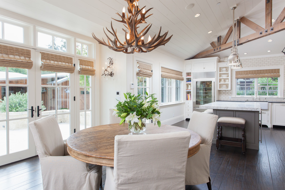 Photo of a country kitchen/dining combo in San Francisco with white walls, dark hardwood floors and no fireplace.