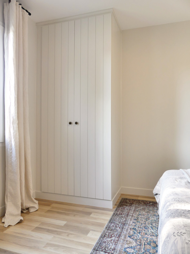 Photo of a mid-sized beach style master bedroom in Nantes with beige walls, light hardwood floors, brown floor and panelled walls.