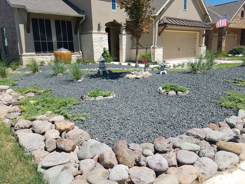 Photo of a mid-sized asian front yard full sun xeriscape for summer in Other with a garden path and natural stone pavers.