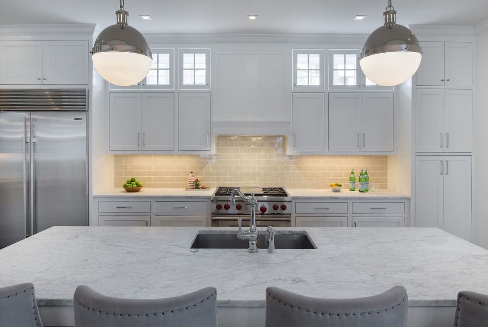 Inspiration for a transitional single-wall eat-in kitchen in Minneapolis with a single-bowl sink, shaker cabinets, white cabinets, marble benchtops, beige splashback, porcelain splashback, stainless steel appliances and with island.