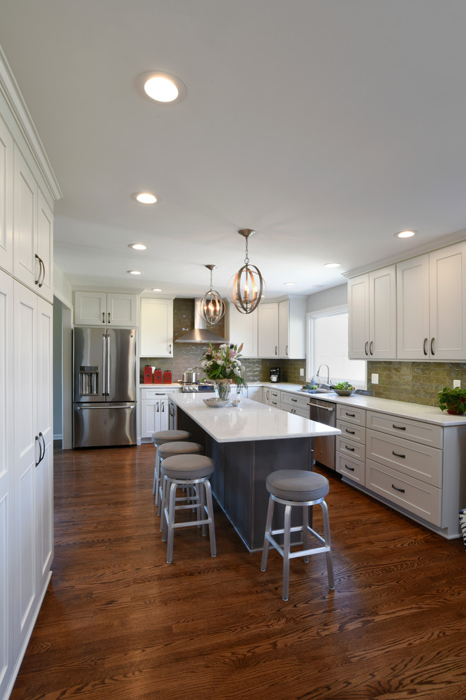 Eat-in kitchen - transitional l-shaped medium tone wood floor eat-in kitchen idea in Orange County with a double-bowl sink, shaker cabinets, white cabinets, marble countertops, gray backsplash, glass tile backsplash, stainless steel appliances and an island