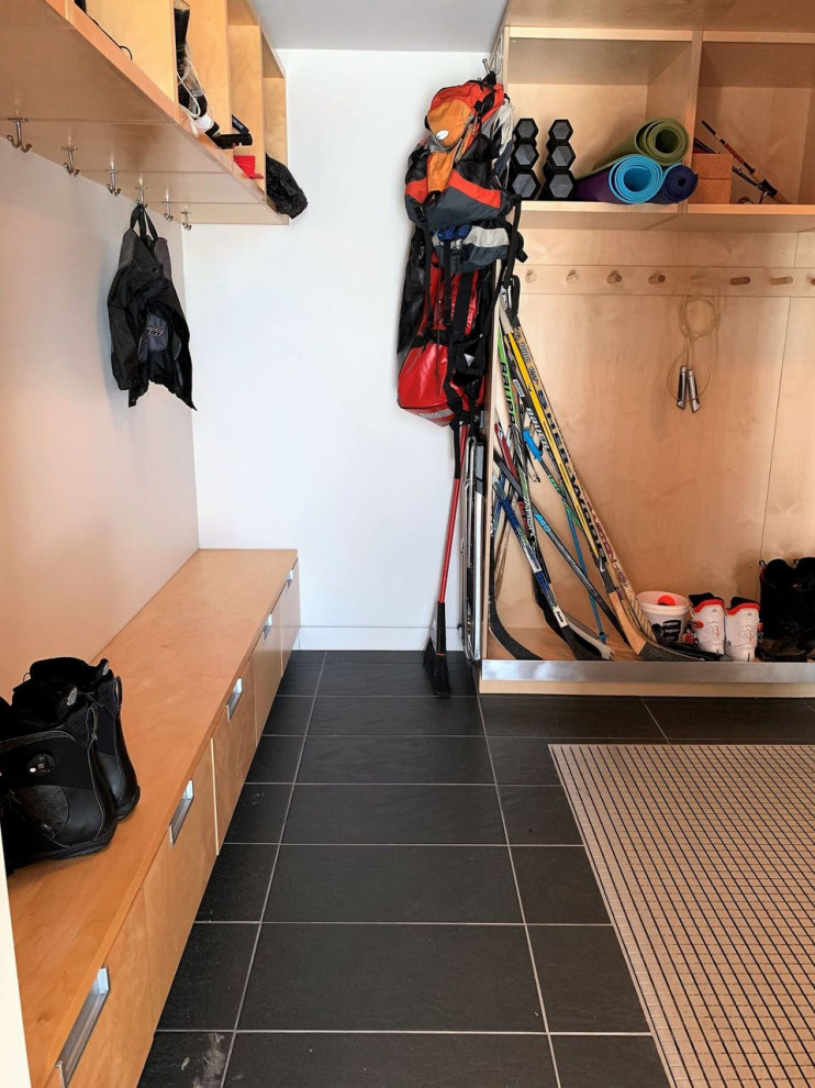 Photo of a large scandinavian mudroom in Toronto with white walls, granite floors, a double front door and black floor.