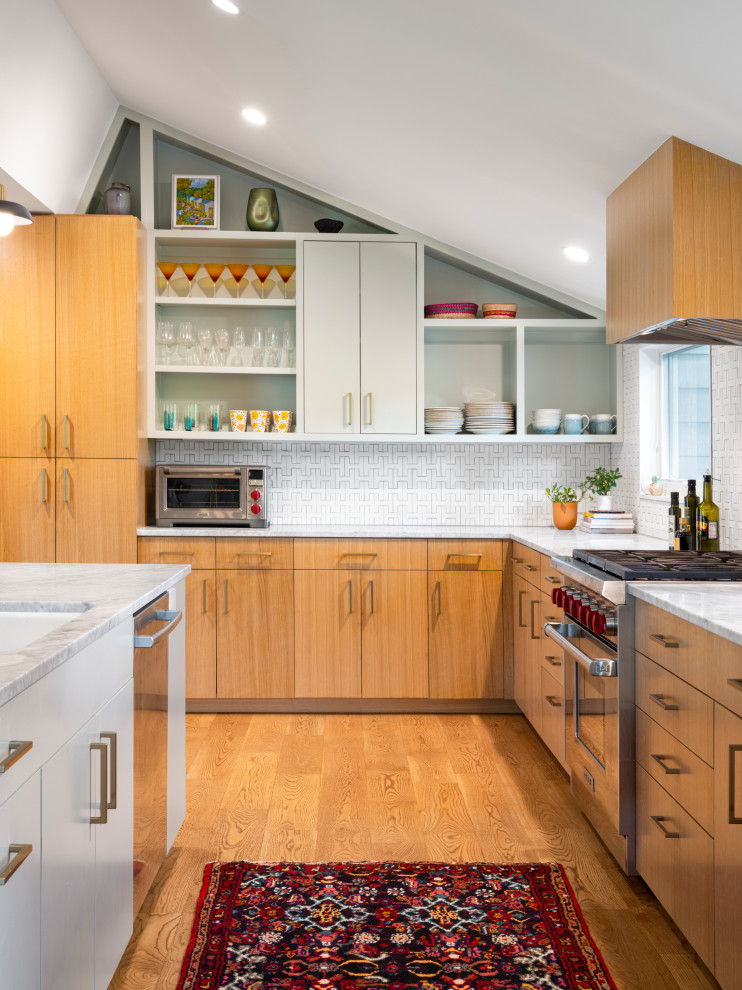 Inspiration for a mid-sized modern l-shaped kitchen in Austin with an undermount sink, flat-panel cabinets, light wood cabinets, quartz benchtops, white splashback, ceramic splashback, stainless steel appliances, light hardwood floors, with island, white benchtop and vaulted.