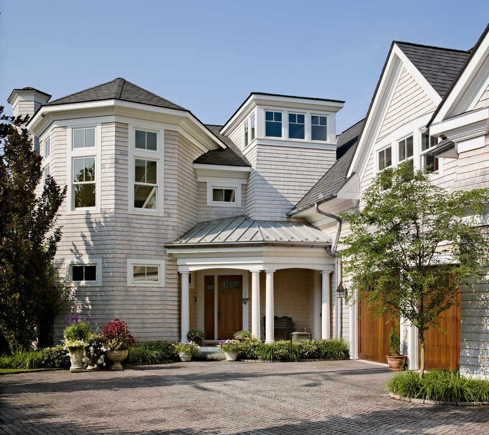 Photo of a beach style two-storey beige exterior in Bridgeport with wood siding.
