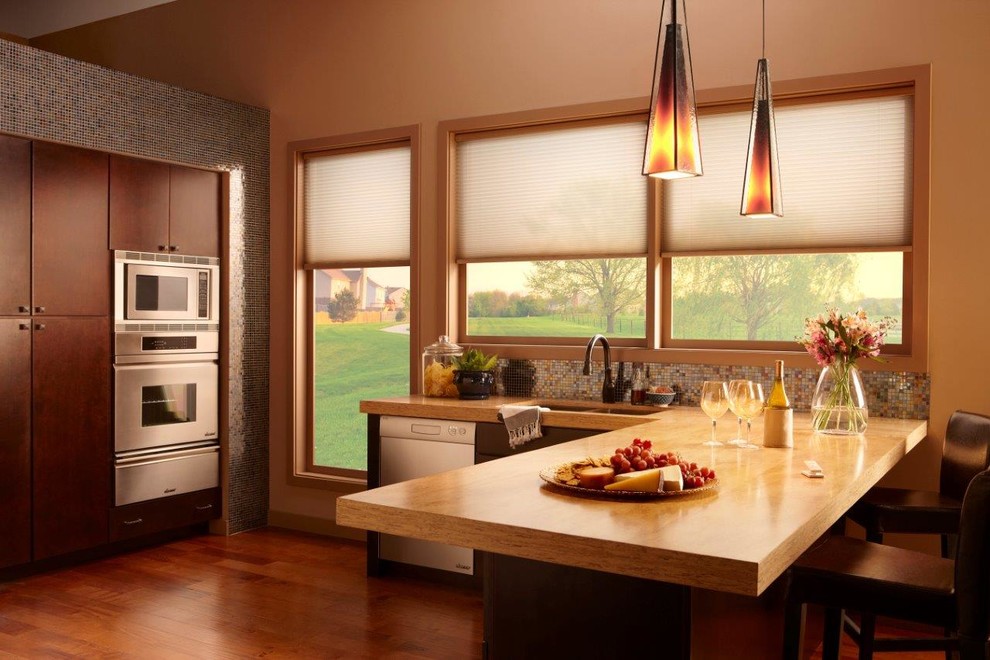 Inspiration for a mid-sized transitional u-shaped medium tone wood floor and brown floor open concept kitchen remodel in Orange County with a double-bowl sink, flat-panel cabinets, dark wood cabinets, wood countertops, multicolored backsplash, mosaic tile backsplash, stainless steel appliances, a peninsula and beige countertops