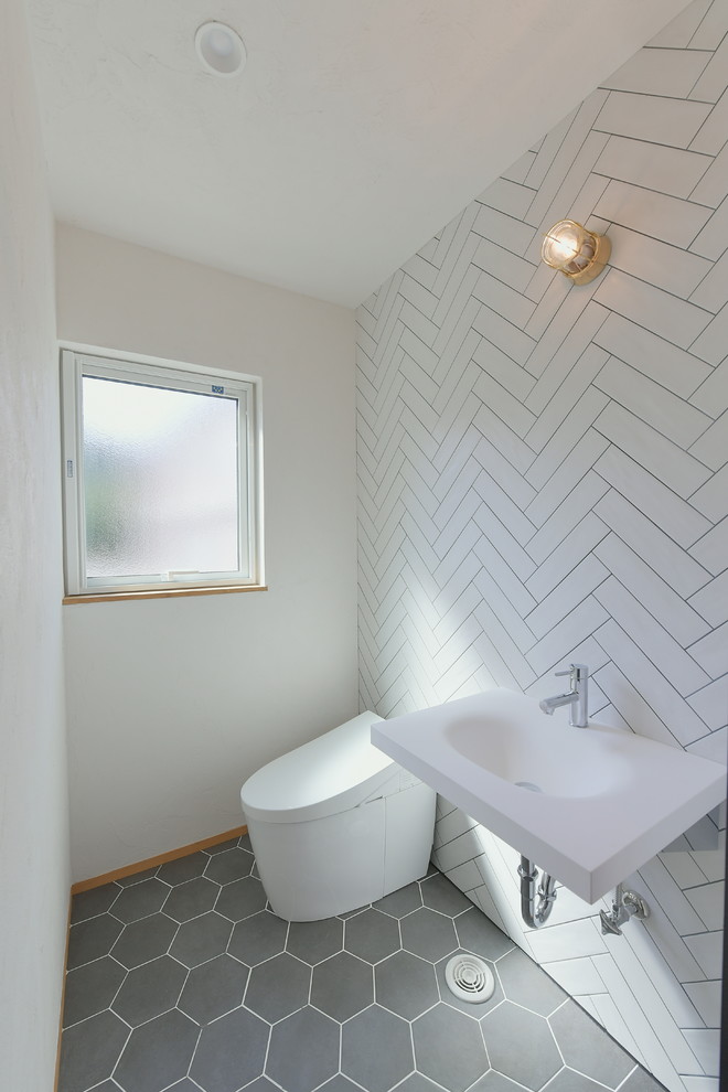 Photo of a powder room in Other with white walls and black floor.