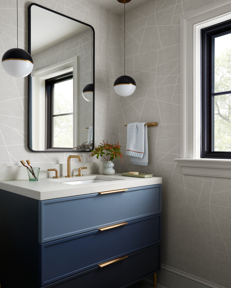 Transitional wallpaper powder room photo with shaker cabinets, blue cabinets, gray walls, an undermount sink, gray countertops and a freestanding vanity