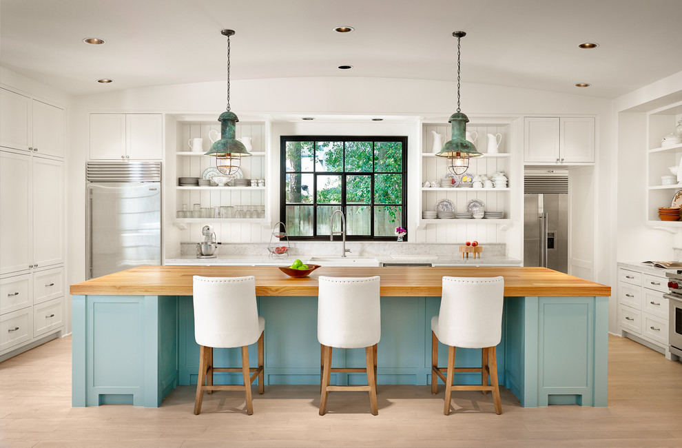 Design ideas for a large beach style u-shaped kitchen in Houston with with island, white cabinets, marble benchtops, stainless steel appliances, light hardwood floors, open cabinets, a farmhouse sink, white splashback and timber splashback.