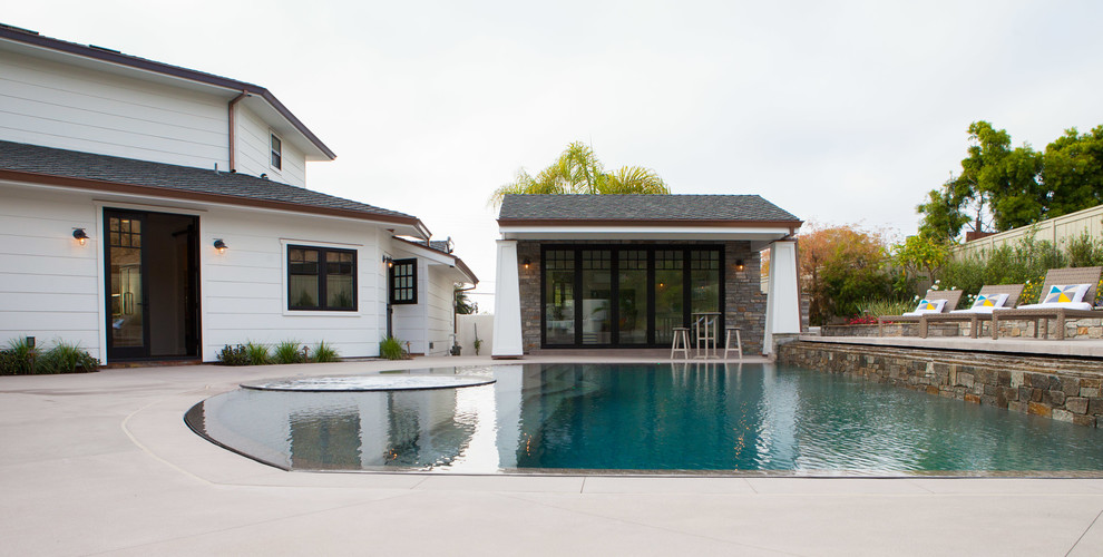 Large arts and crafts backyard custom-shaped natural pool in San Diego with a pool house and concrete slab.