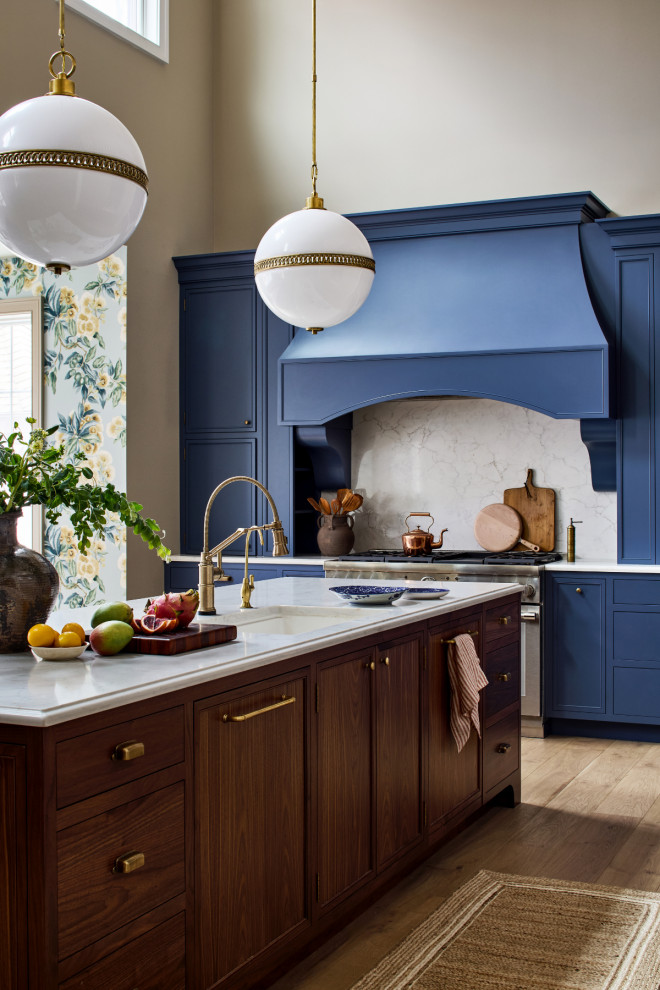 Large transitional galley light wood floor, brown floor and vaulted ceiling open concept kitchen photo in Baltimore with a drop-in sink, gray backsplash, stainless steel appliances, an island, blue cabinets, shaker cabinets, quartzite countertops, marble backsplash and white countertops