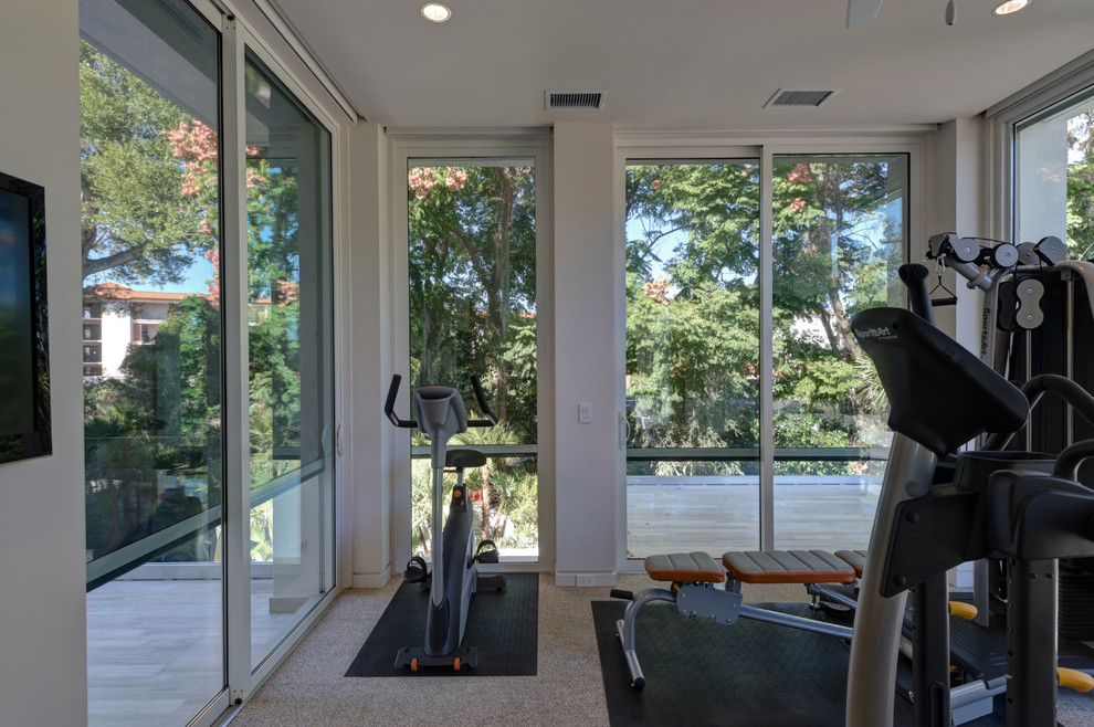 Mid-sized modern multipurpose gym in Orlando with white walls, carpet and beige floor.